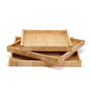 Stack of three square rattan trays with brass corners on a white background
