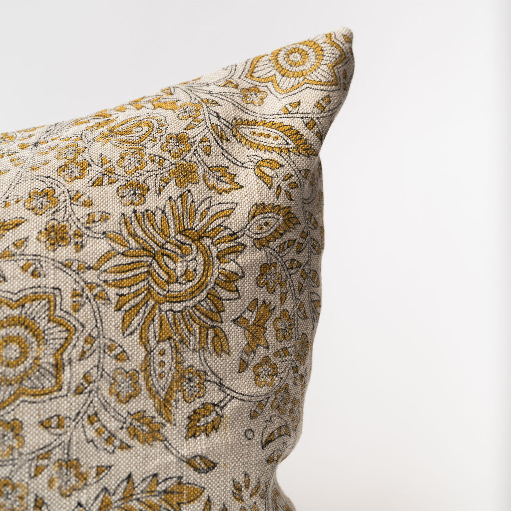 Close up of Long lumbar pillow with ochre yellow botanical print on a white background