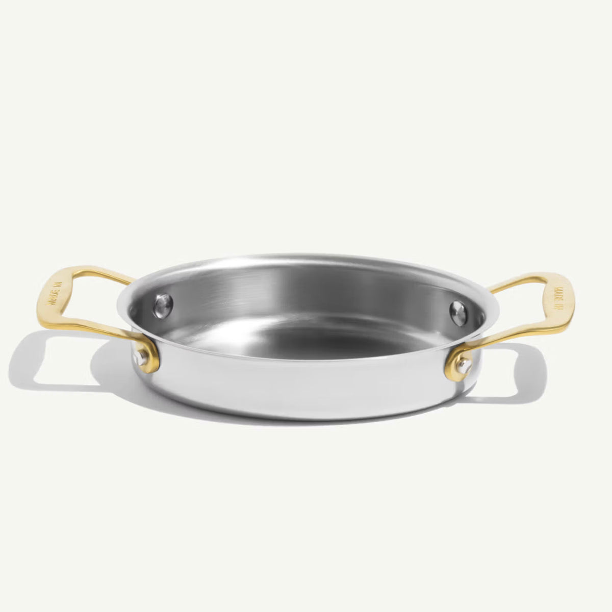 Made In Stainless Steel Gratin Dishes in Antiqued Brass on plain background.