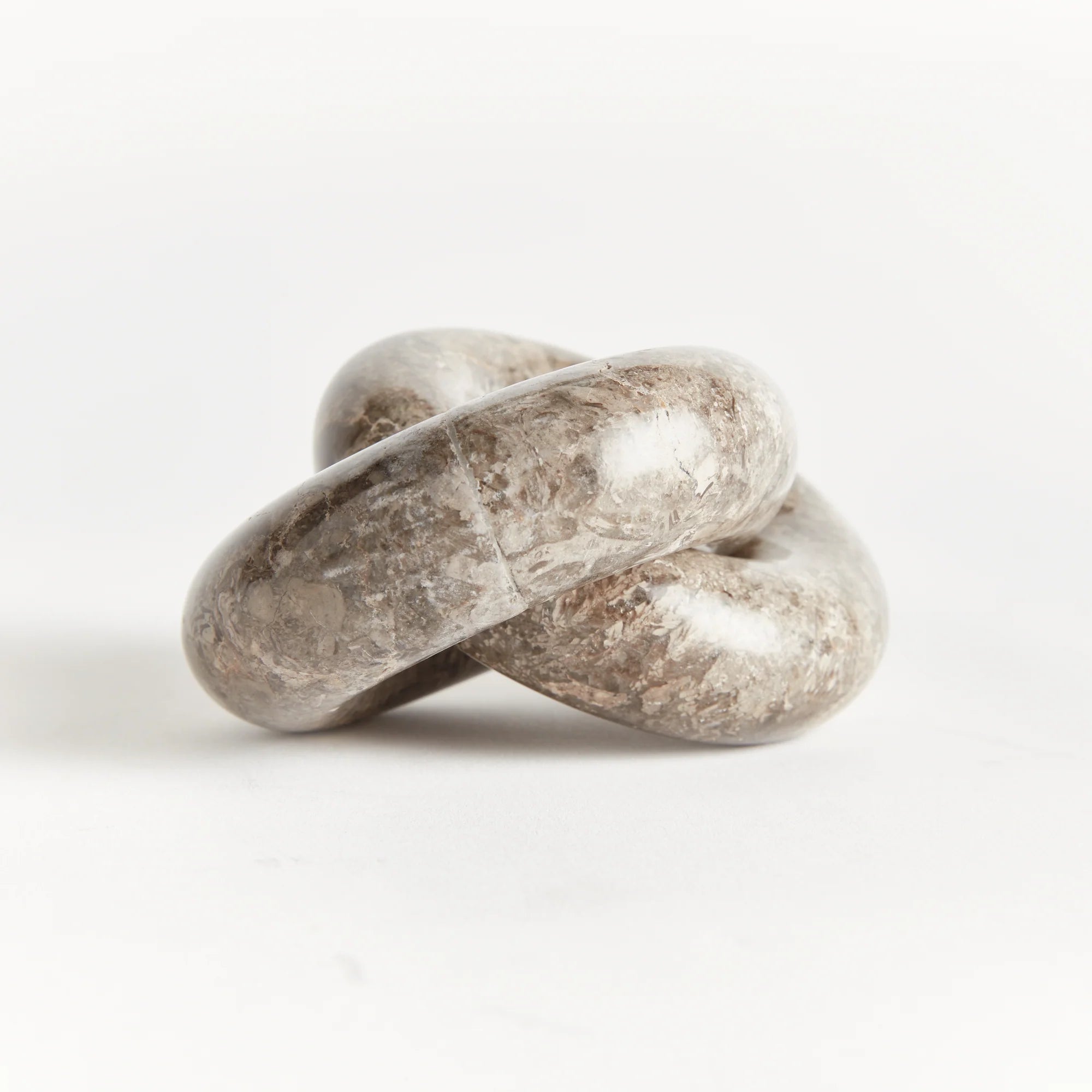 Marble Links Sculpture on white background at Addison West.