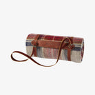 Plaid picnic blanket with leather straps on a white background