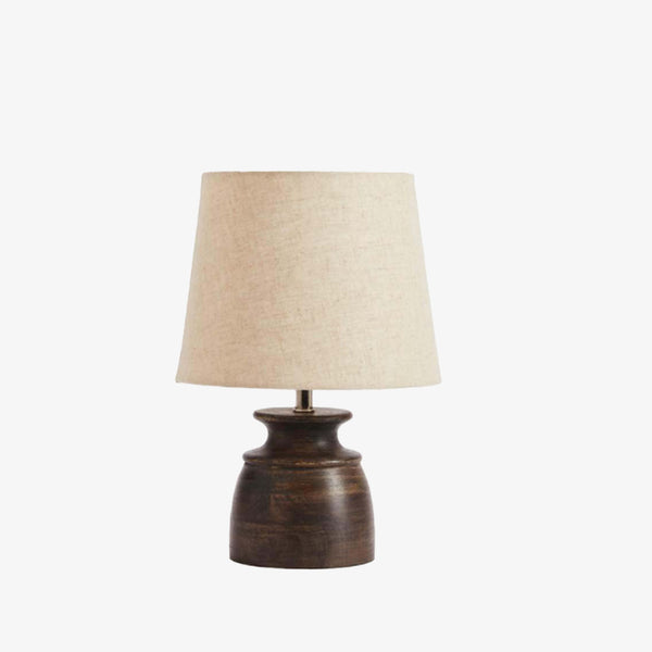 Washed black mango wood base table lamp with beige linen shade on a white background