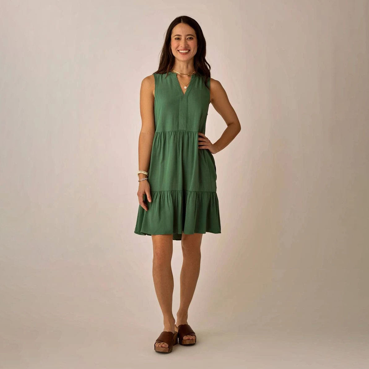 Nellie Dress in Dark Grass shown on model on plain background.