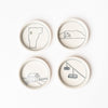 Four small white handmade dishes with illustrations of vermont places and past times on a white background