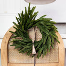 Norfolk & Cypress Mixed Real Touch Mini Wreath, 12" on a chair at Addison West