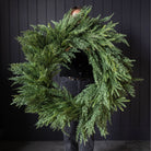 Norfolk & Cypress Mixed Real Touch Wreath, 34" in front of a black wall at Addison West