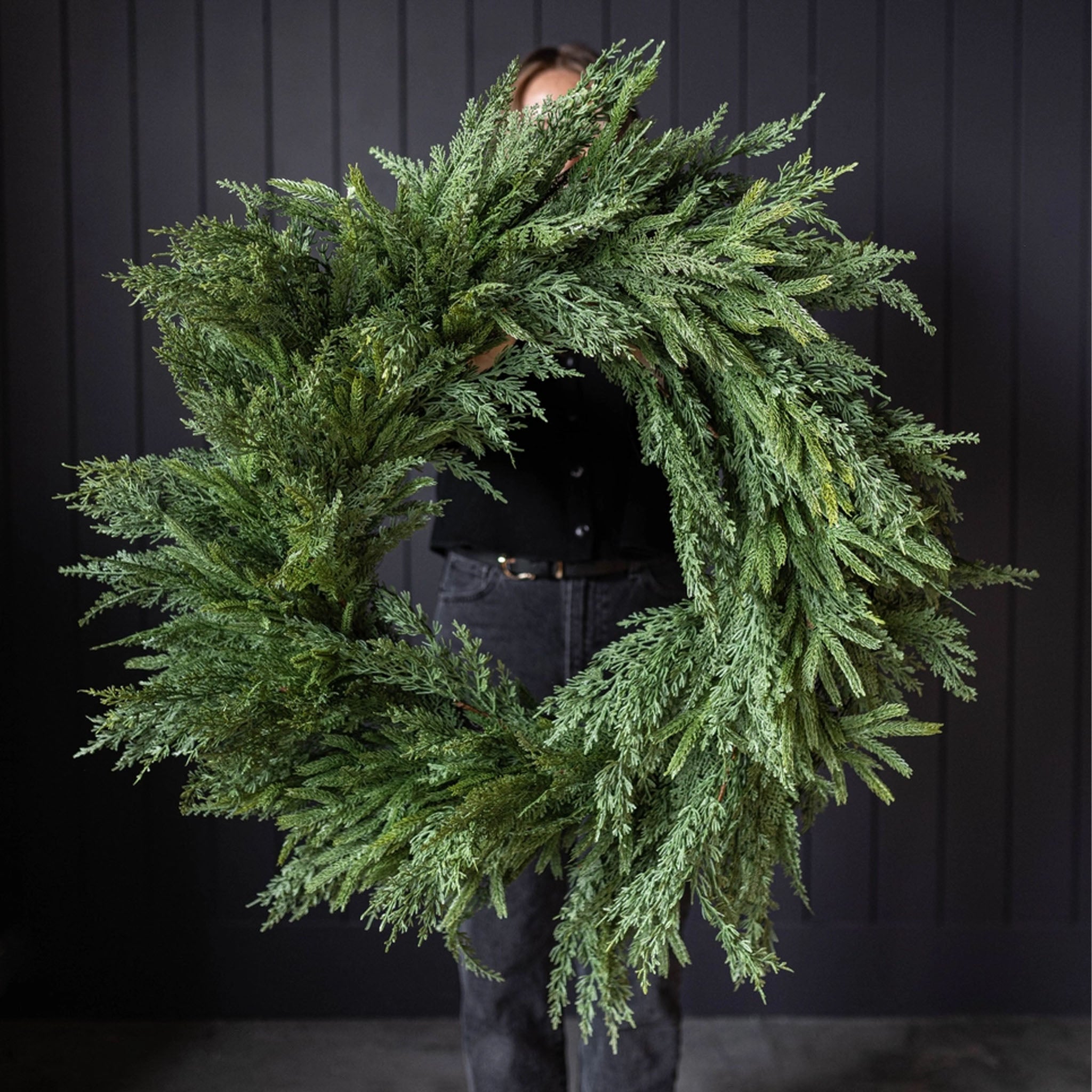 Norfolk & Cypress Mixed Real Touch Wreath, 34" in front of a black wall at Addison West