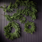 Norfolk & Cypress Mixed Real Touch Wreath, 34" in front of a black wall at Addison West