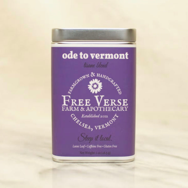 Metal Tin with purple label of Free Verse apothecary Ode to vermont Loose Leaf Herbal Tea Blend on a beige background