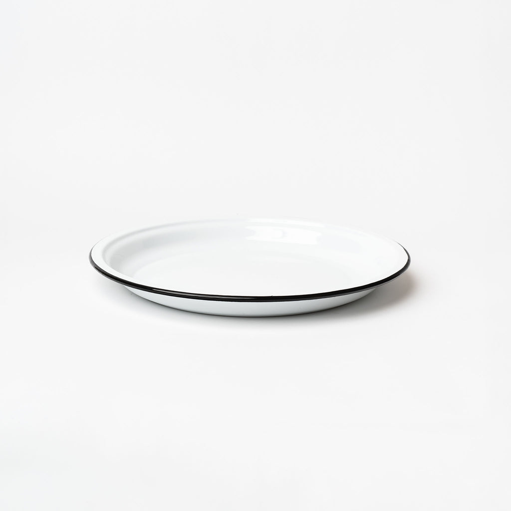 White round enamelware tray with black painted edge on a white background