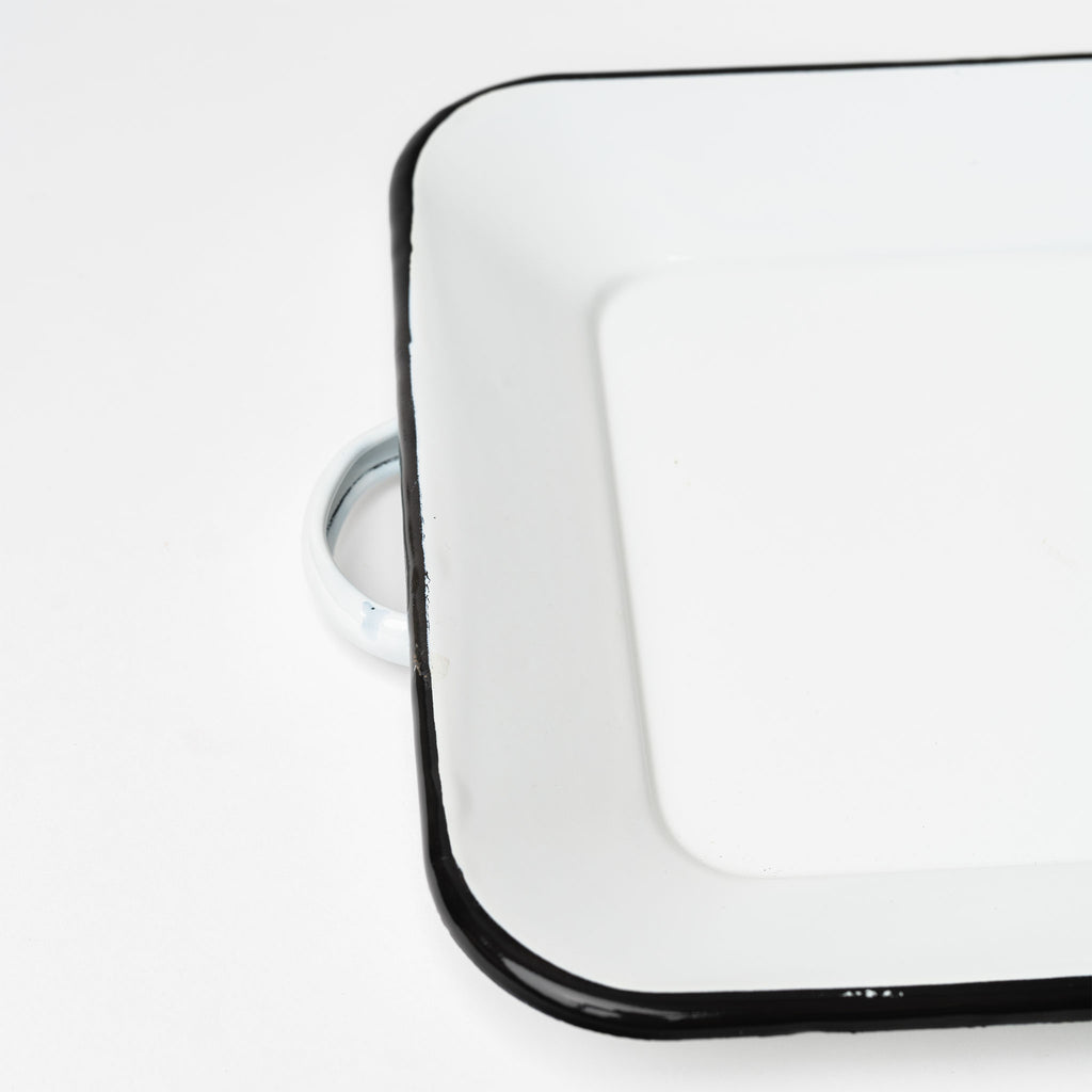 White enamel tray with black edge and handles on a white background