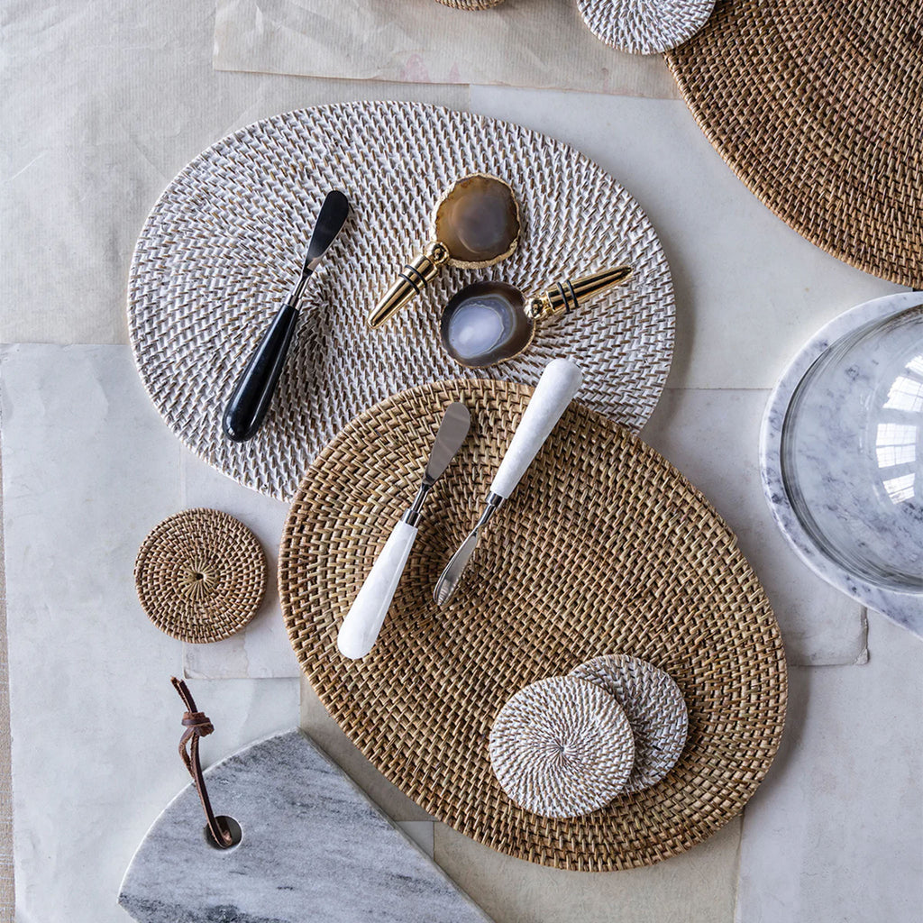 Stack of rattan placemats and coasters  in natural and white wash on a white table