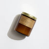 Brown jar of PF Candle Amber and moss candle on a white background