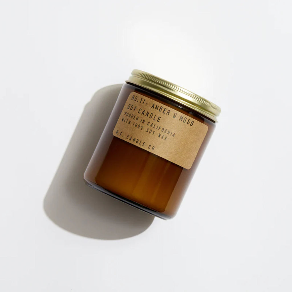 Brown jar of PF Candle Amber and moss candle on a white background