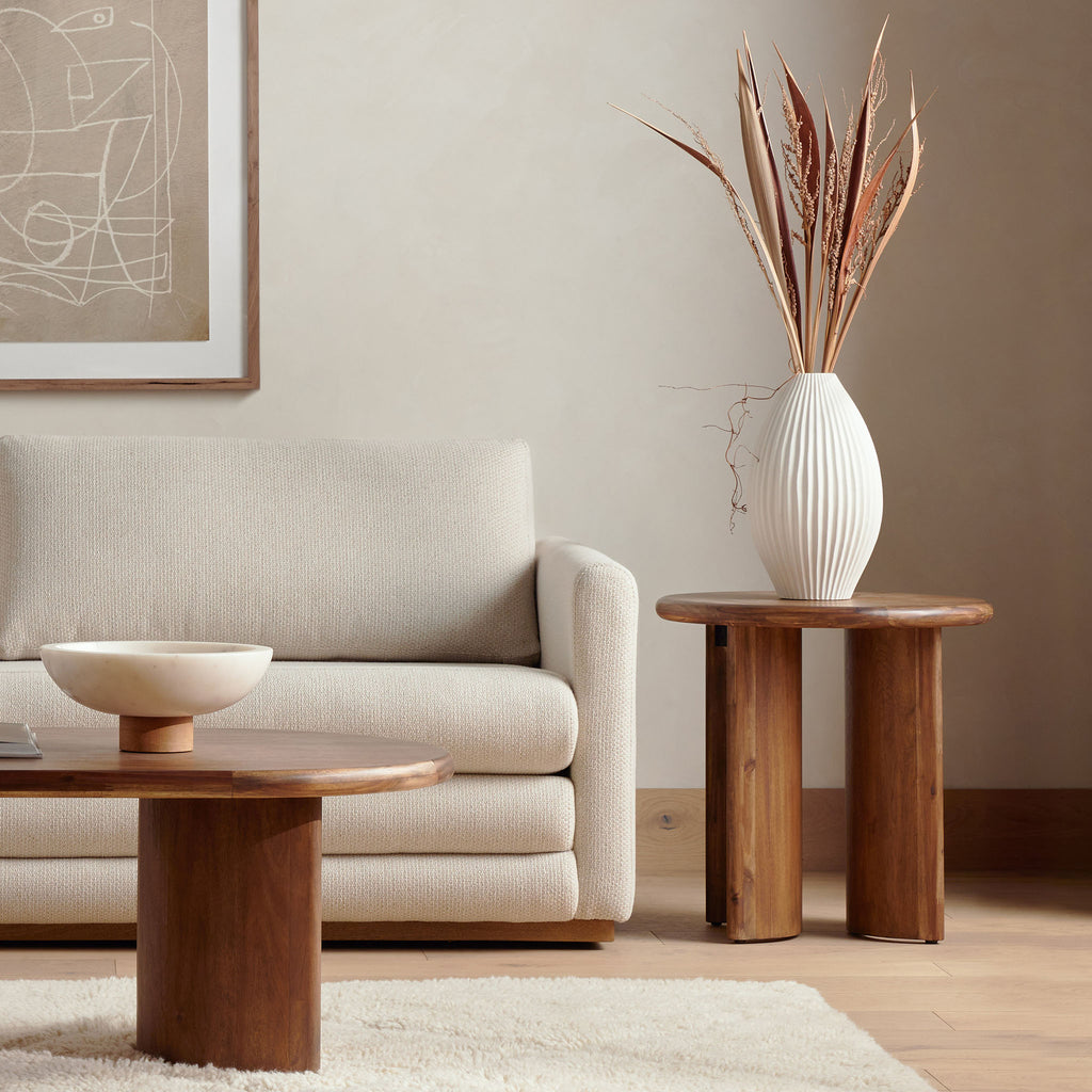 Four Hands furniture brand Four Hands Paden End Table in Brown Acacia in a living room with beige walls and creme sofa