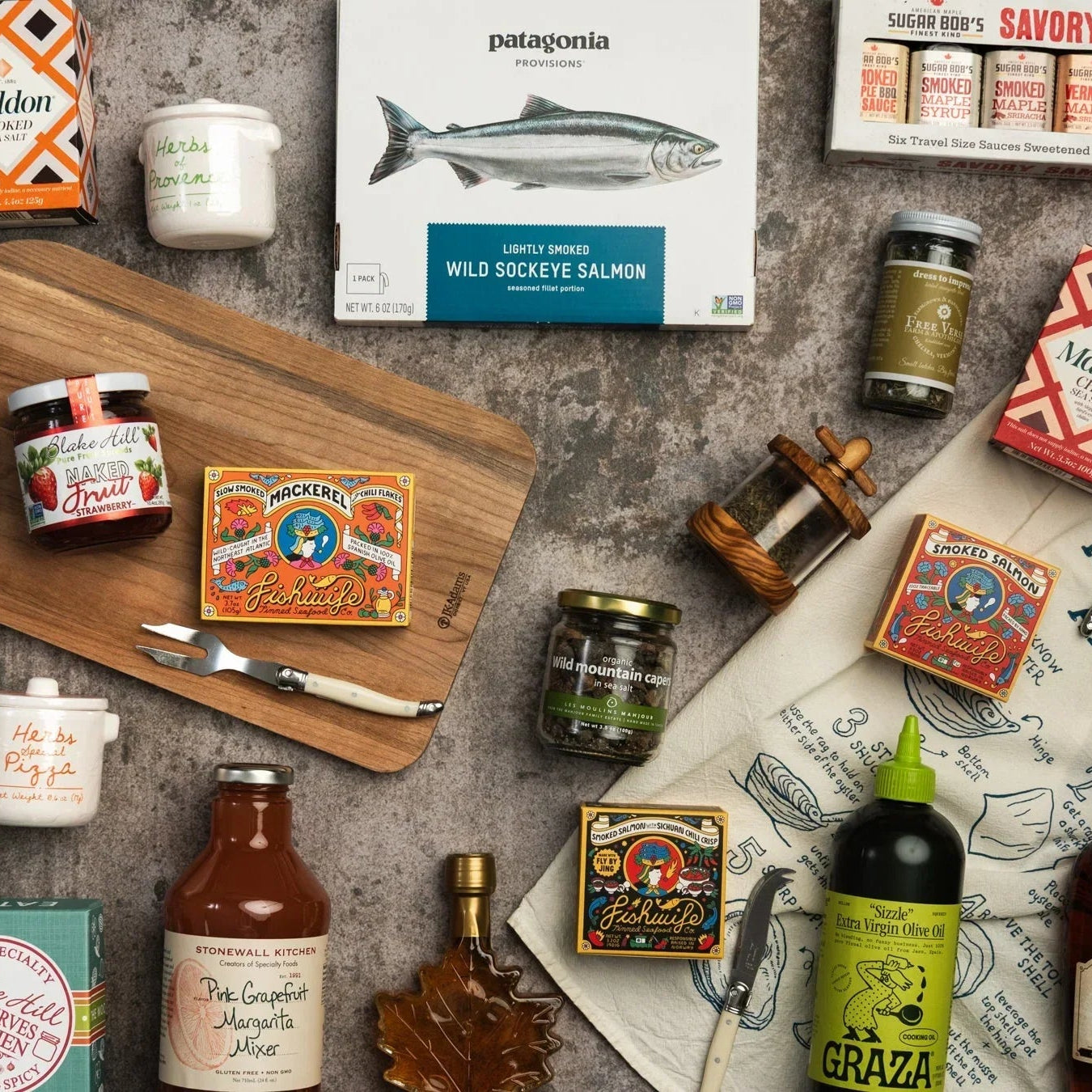 Collection of food products including jars, bottles, and a cutting board on a gray surface in the Addison West pantry collection.