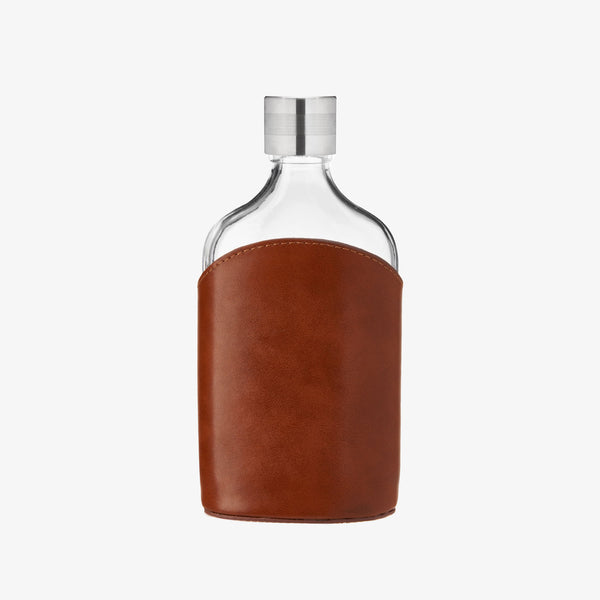 Leather wrapped glass flask on a white background