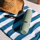 High Camp Parkside Flask in Juniper Green on a beach towel at Addison West