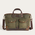 Green bag with brown leather accents on a light gray background