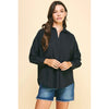 Brunette model wearing jean shorts and black boots and black drop shoulder long sleeve shirt 
