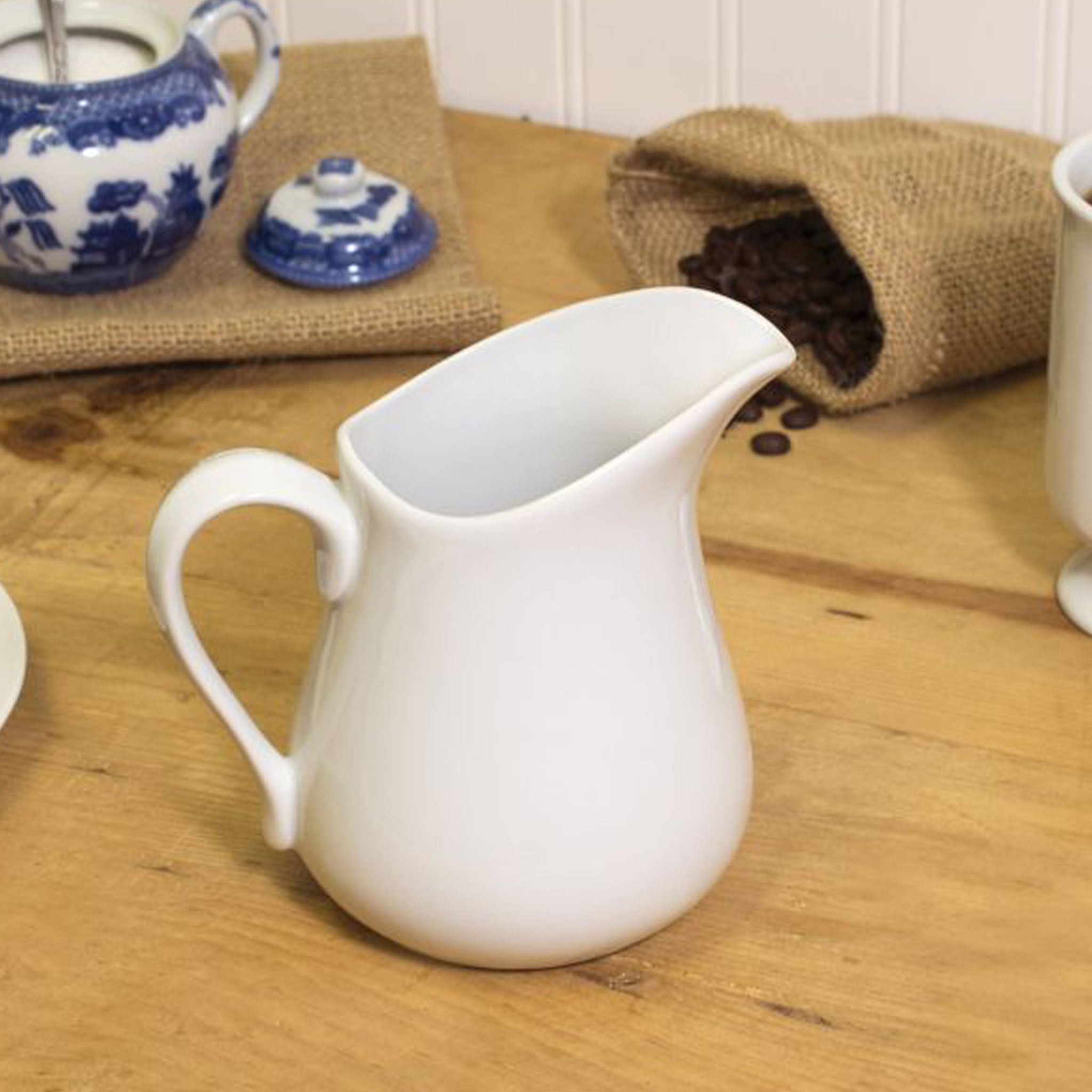 small white porcelain pitcher on a wood surface