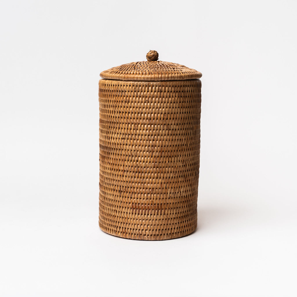 Rattan toilet paper holder with lid on a white background