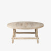 Whitewashed wood round coffee table with square dowel legs and bracing on a white background