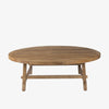 Honey stained wood round coffee table with square dowel legs and bracing on a white background