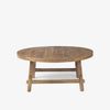 Honey stained wood round coffee table with square dowel legs and bracing on a white background