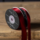 Satin Ribbon in Red, Small on a wood table at Addison West