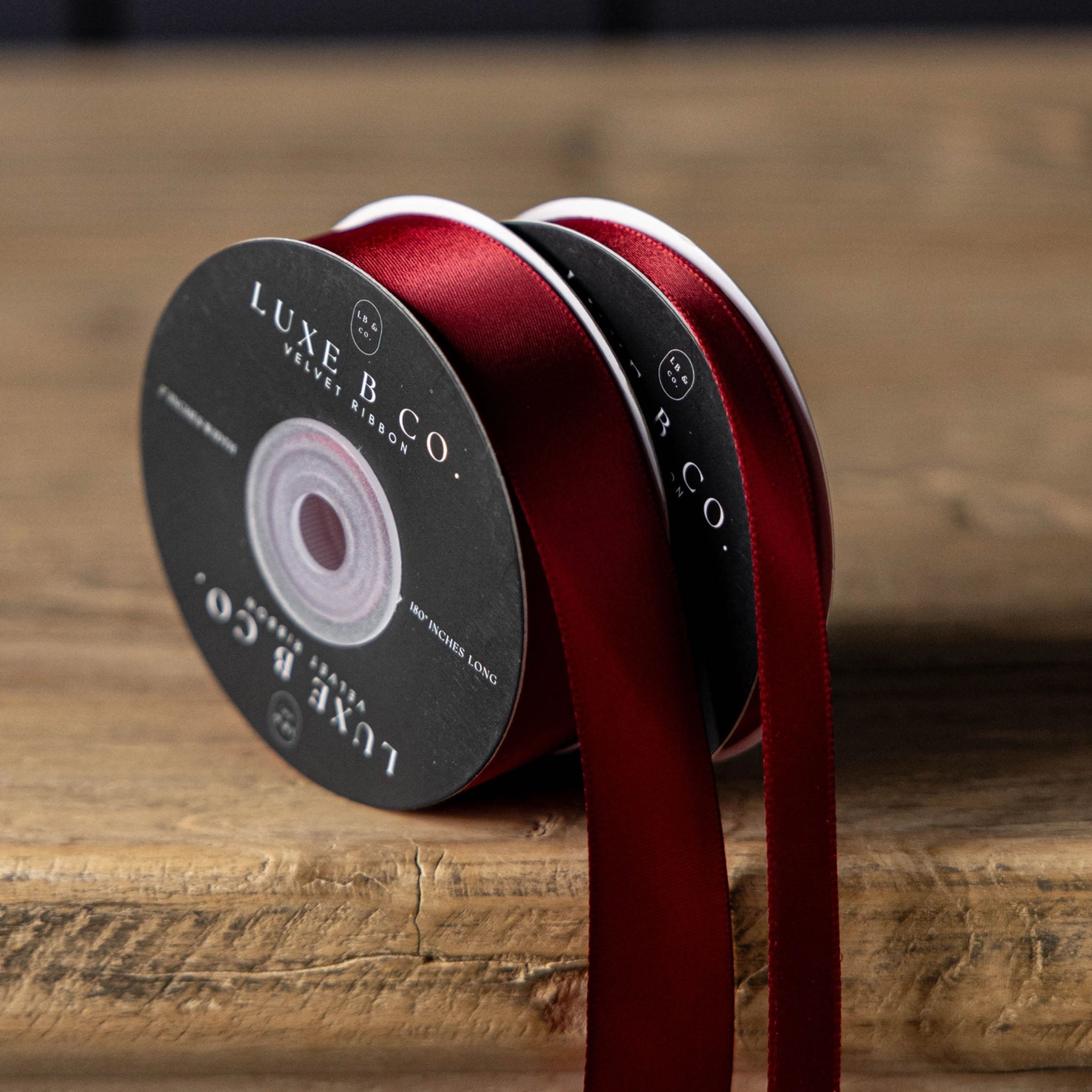 Satin Ribbon in Red, Small on a wood table at Addison West