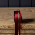 Satin Ribbon in Red, Small on a wood table at Addison West