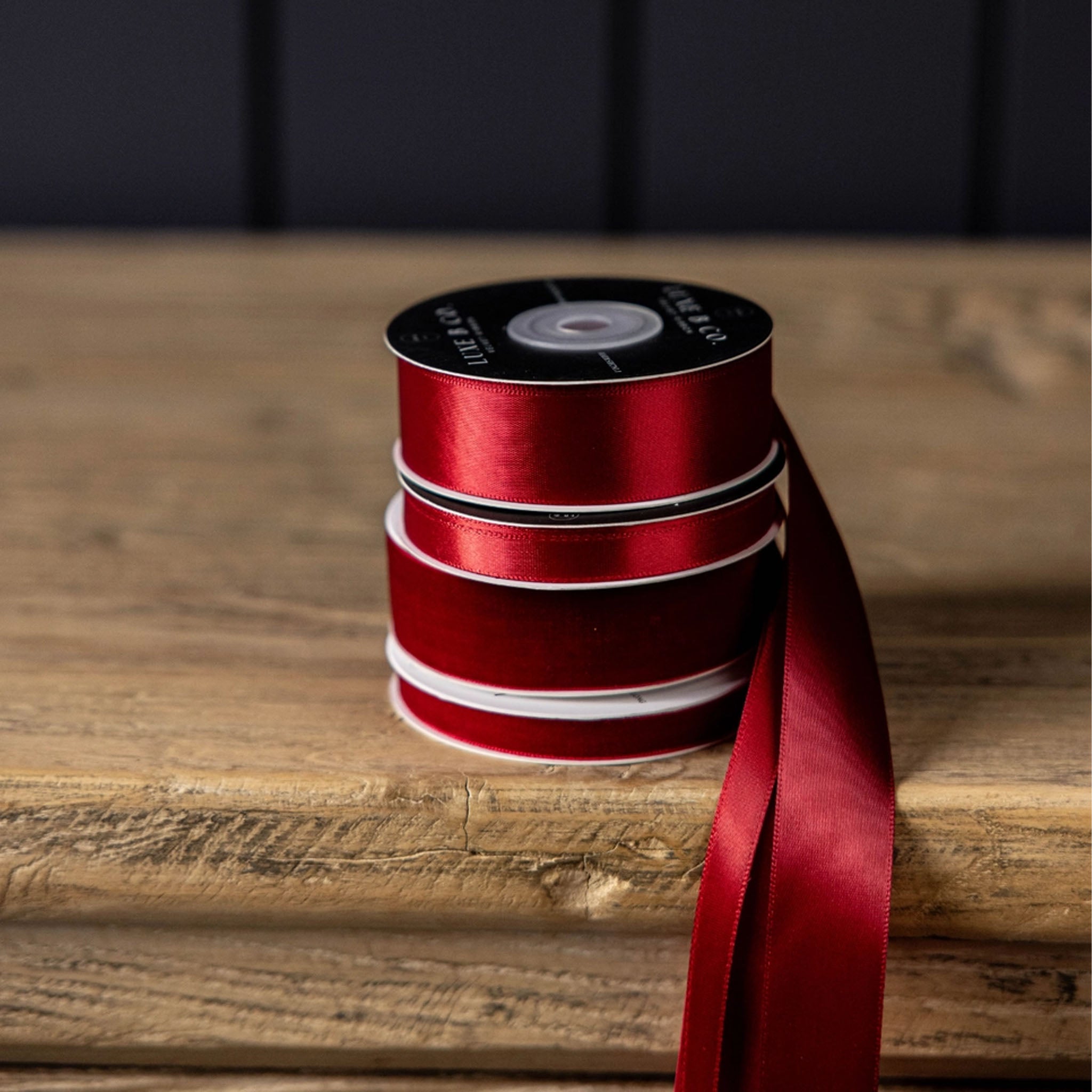 Satin Ribbon in Red, Medium on a wood table at Addison West