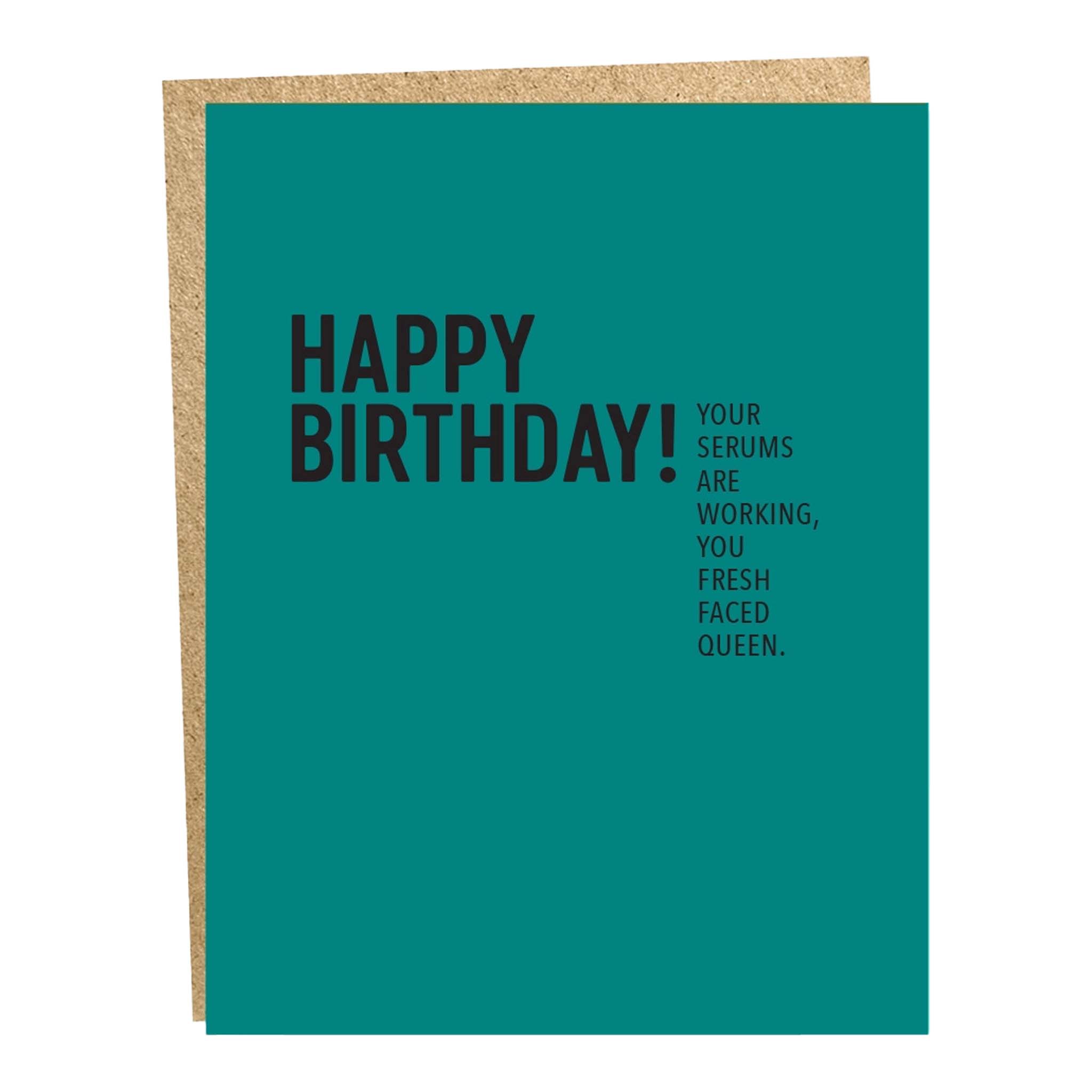 A blue greeting card with text 'HAPPY BIRTHDAY! Your serums are working, you fresh faced queen.' and a brown envelope.