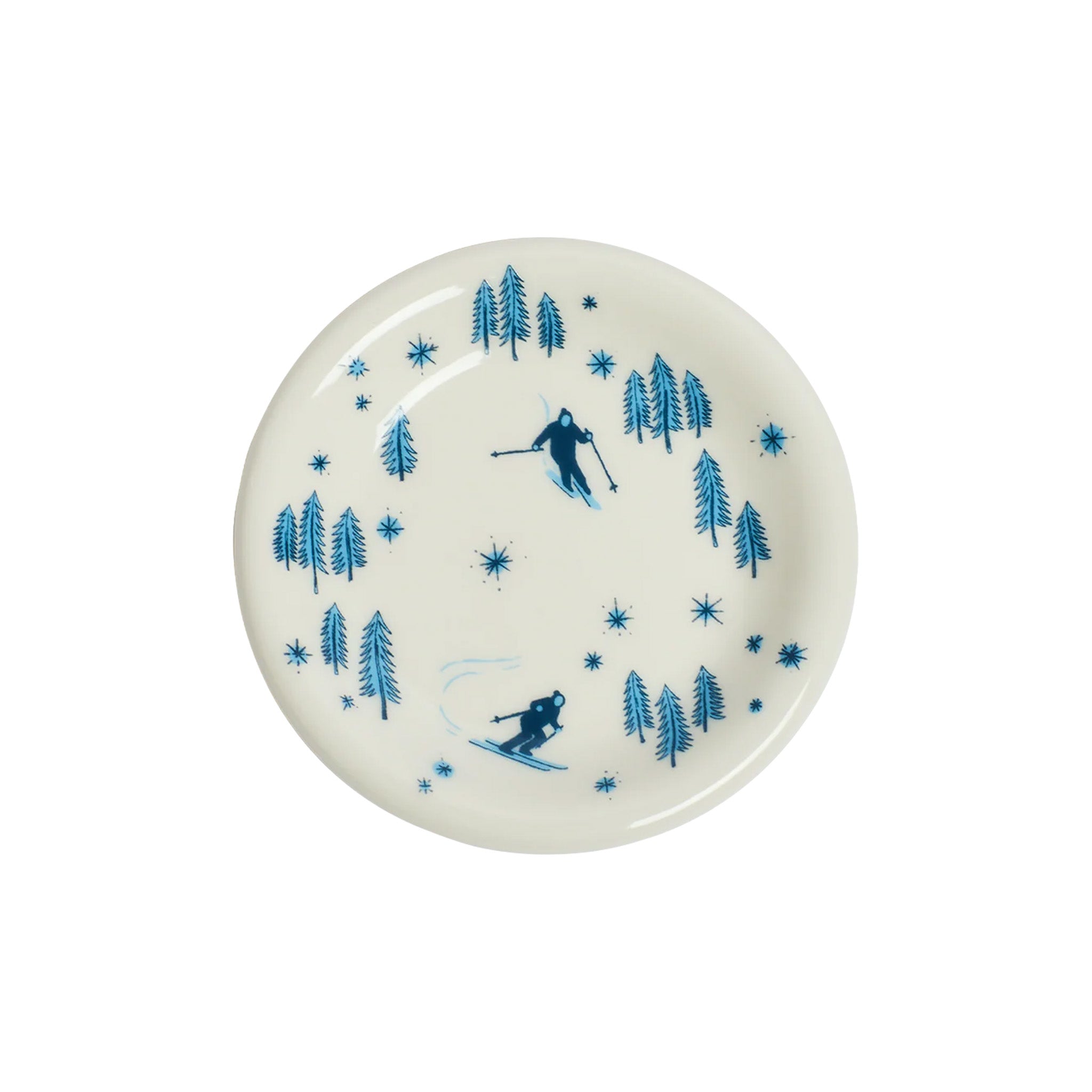 Round ceramic plate with blue skiing and tree design on a white background