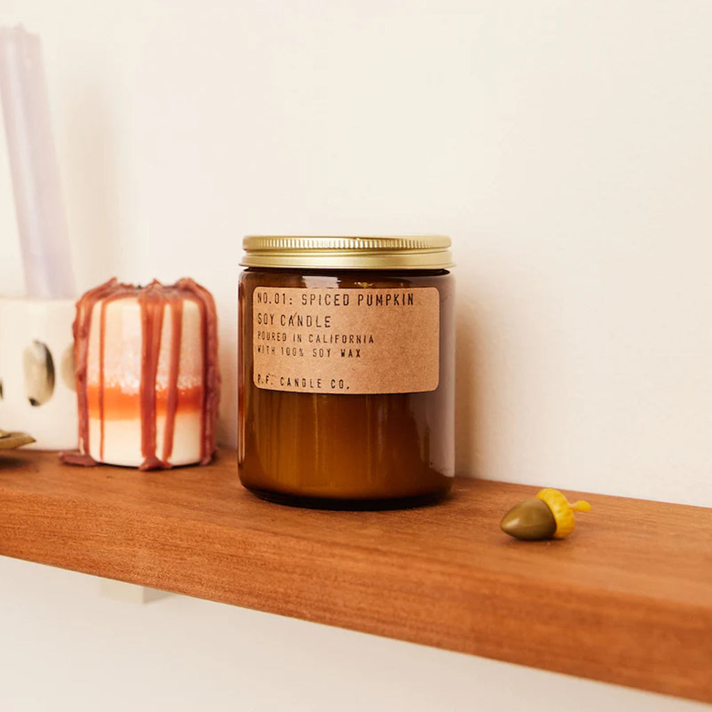 Brown jar of PF Candle Spiced Pumpkin on a wood shelf