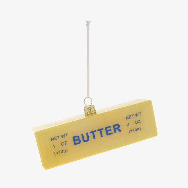 Stick of butter glass holiday ornament by Cody Foster on a white background