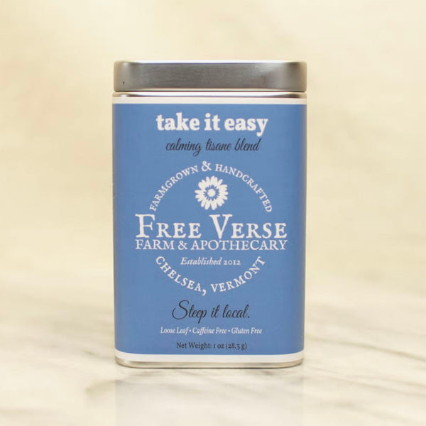 Metal Tin with blue label of Free Verse apothecary take it easy Loose Leaf Herbal Tea Blend on a beige background