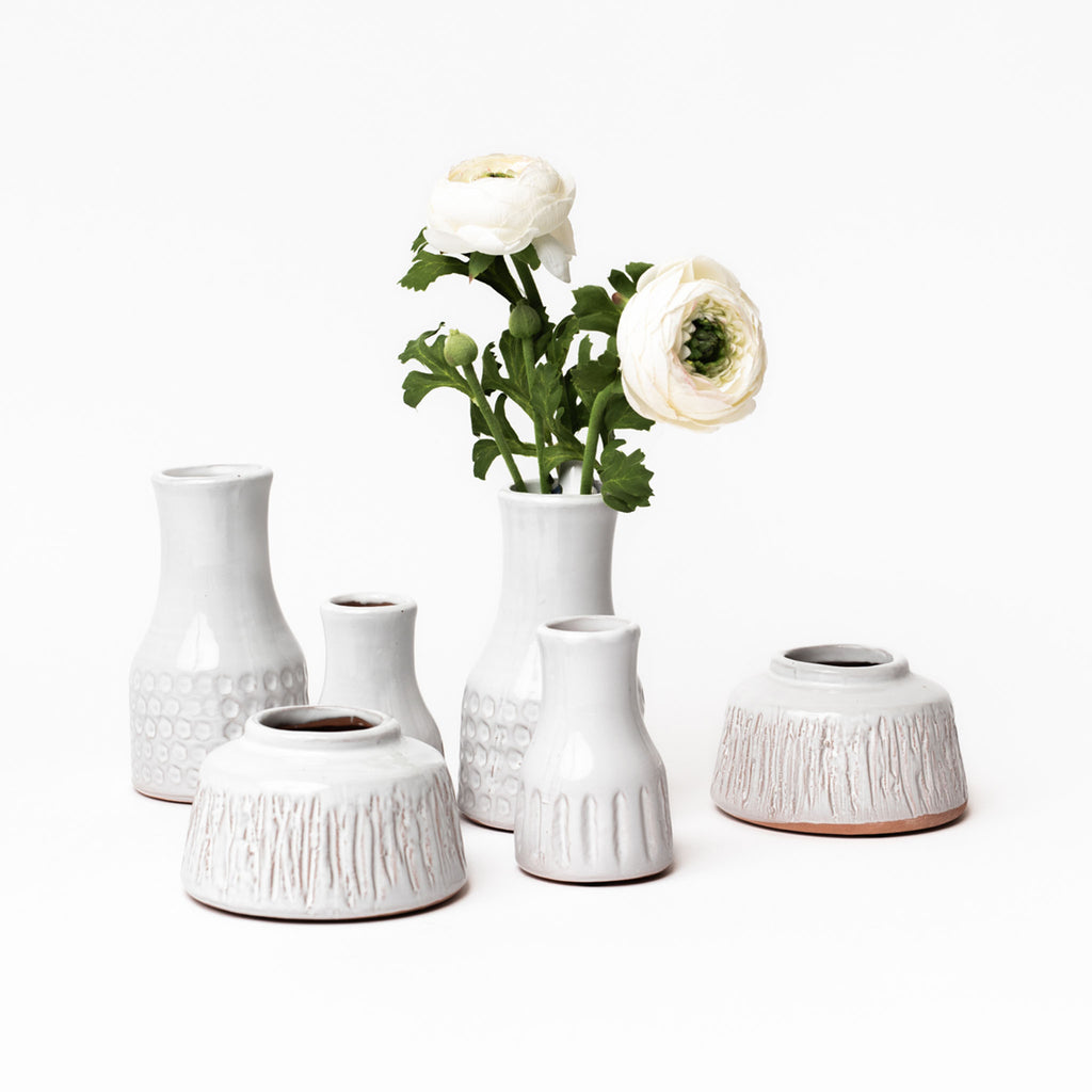Collection of small white terracotta vases on a white background