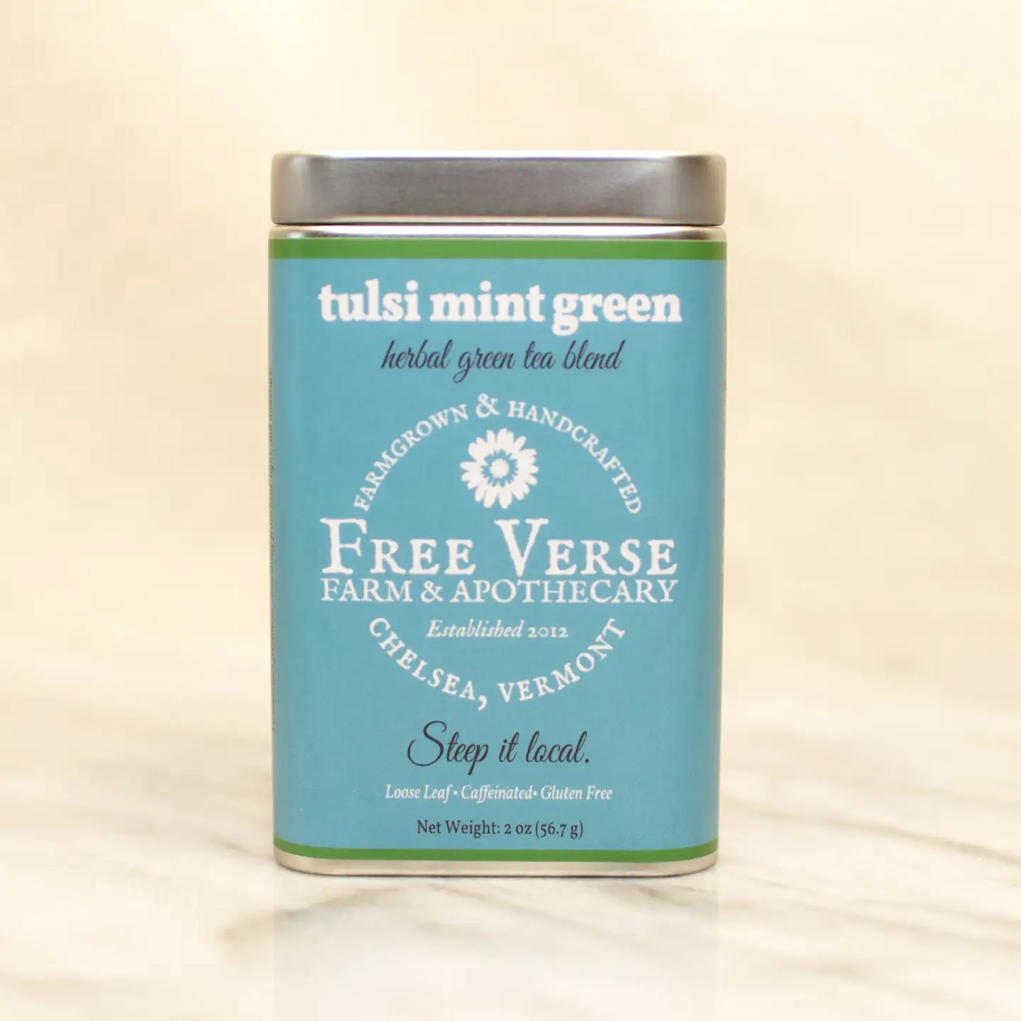 Blue tin of Free Verse Apothecary Tulsi Mint Green Loose Leaf Green and Herbal Tea Blend on a neutral background