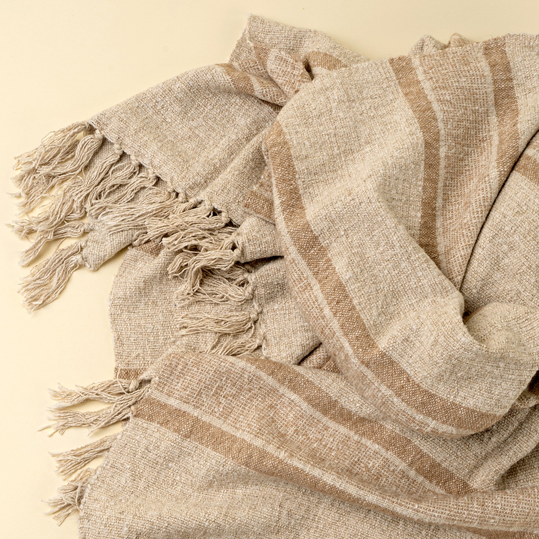 Tulum Striped Throw in Clay on a beige background at Addison West