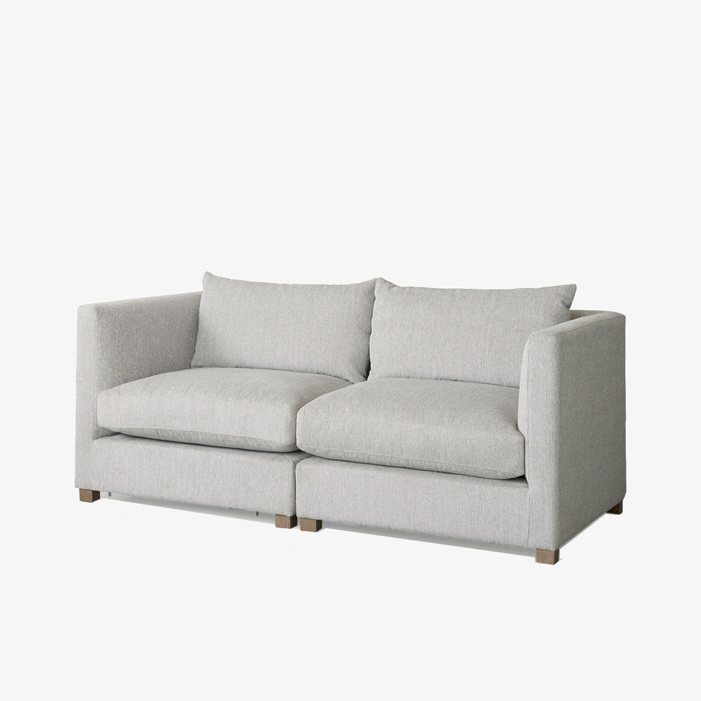 Two piece modular sofa in light grey fabric on a white background