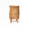 Hand woven rattan flower vase with oak feet on a white background