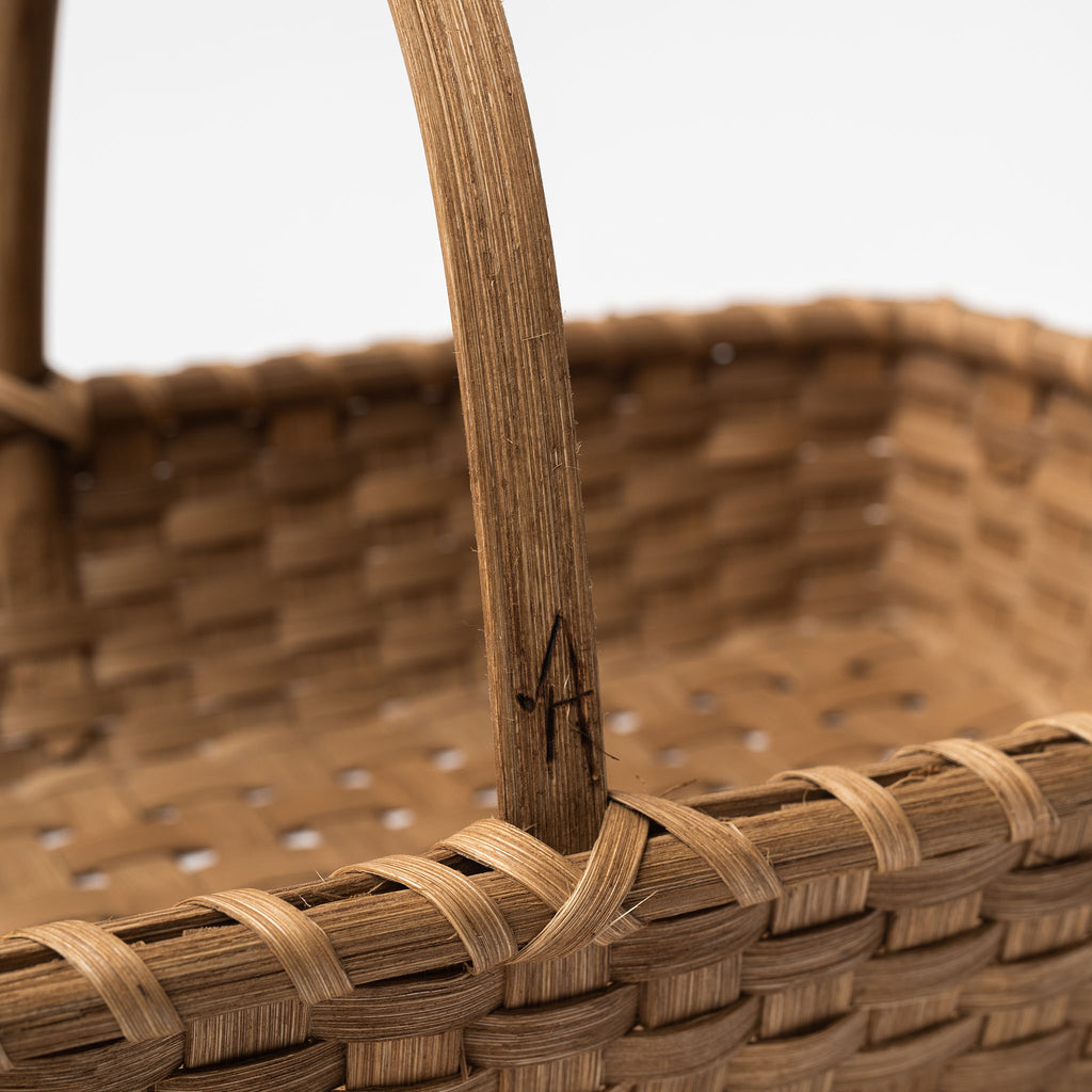 Close up of handle on rattan woven harvest basket