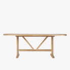 Oval wood dining table with trellis style base on a white background