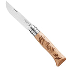 Opinel knife with wooden handle and engraved skiing motif on a white background