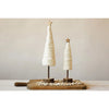 Two white wool christmas trees with gold stars and wood bases on a wood tray in front of a white wall