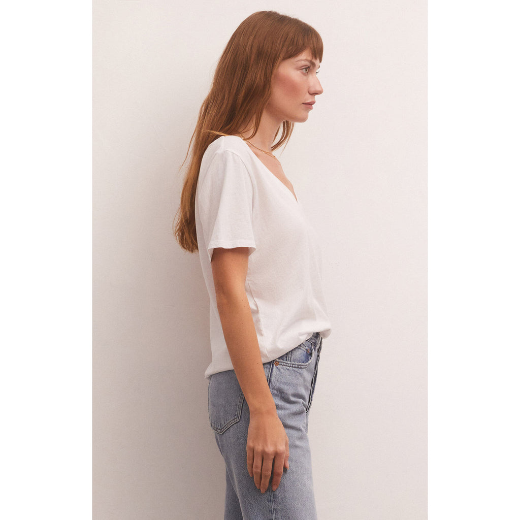 Model wearing loose fitted Z Supply Girlfriend V-Neck Tee in White with jeans and in front of a white wall