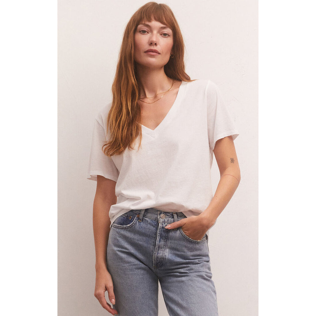 Model wearing loose fitted Z Supply Girlfriend V-Neck Tee in White with jeans in front of a white wall