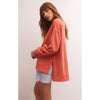 Model wearing Z Supply Modern Weekender in Lava with cut off jean shorts in front of a white wall